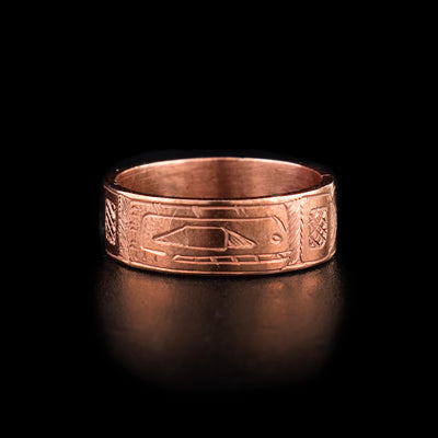 This Orca Ring has a single, copper band with a side profile depiction of the Orca carved into it. The head of the orca is show with its teeth and eyes included and there are cross hatching designs in the background of the scene.