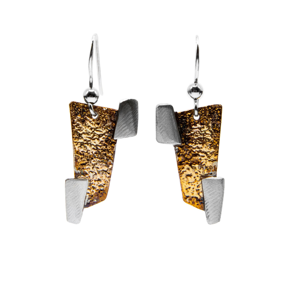 Each one of these oxidized silver earrings is in the shape of 3 rectangles. A large orange and brown one in the center and two small silver ones on the corners.