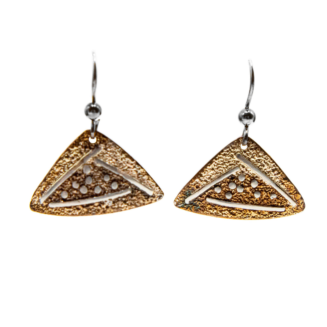 These oxidized silver and triangular gold earrings are triangular-shaped and orange and light brown in colour. There are abstract silver lines and dots on each earring.