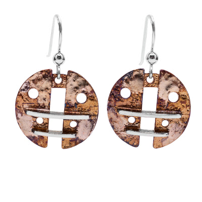 These oxidized silver earrings are circular in shape and light brown and beige in colour. Each earring has symmetrical circular holes cut out as well as linear sterling silver accents.