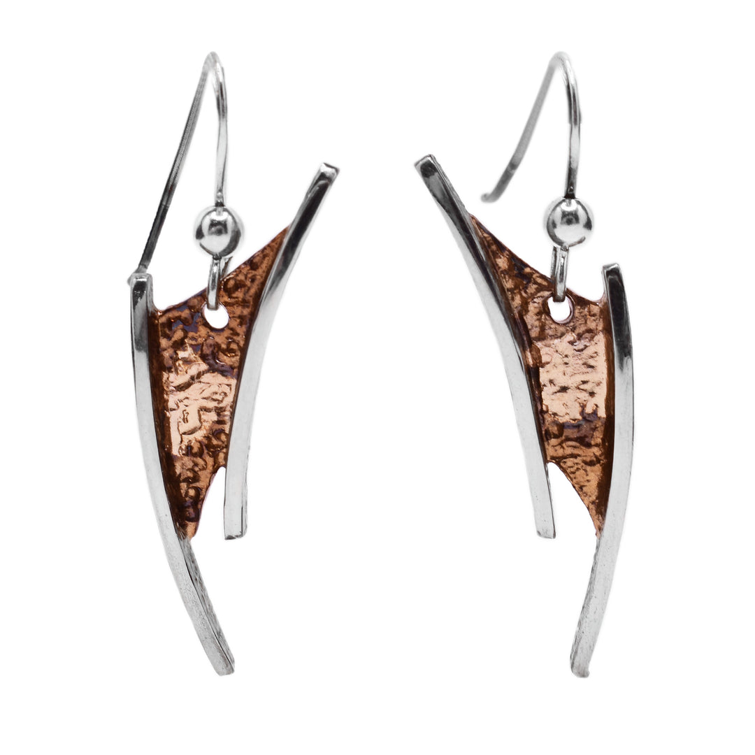 These oxidized silver earrings are in an abstract curved shaped with sterling silver accents on each side. The base of each earring is light brown and beige in colour.