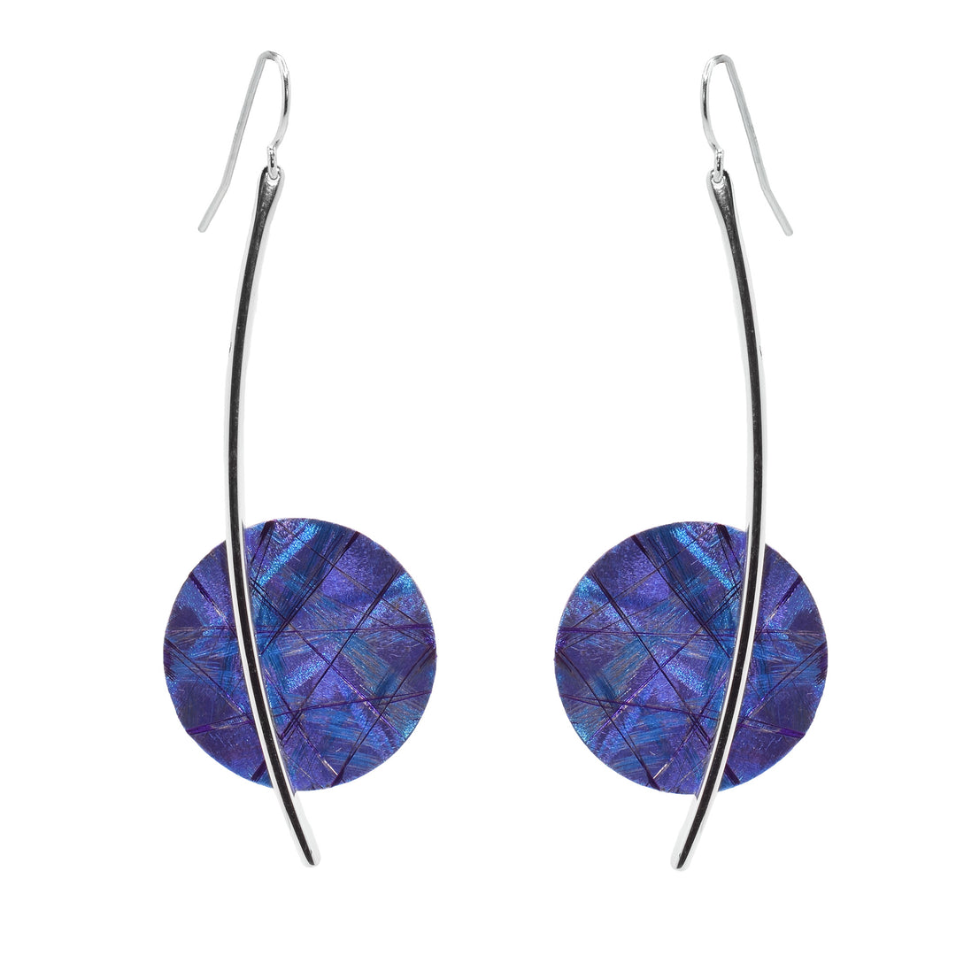 These long, titanium drop earrings have sterling silver wires that go down with circle titanium pieces attached to them. There are purple and blue designs on the titanium. 