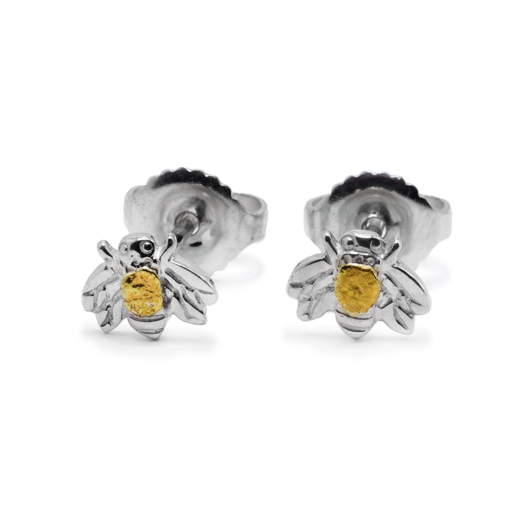 These gold bee earrings are made from sterling silver. They have carvings on them and are shaped like bees. The legs, wings and eyes are detailed. There is a piece of 22K gold nugget in the center of each stud and the studs are very small.
