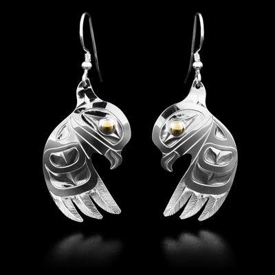 Each owl earring is in the shape of an owl with a large, spread out wing underneath the head. The eye of the owl is made from 14k yellow gold.
