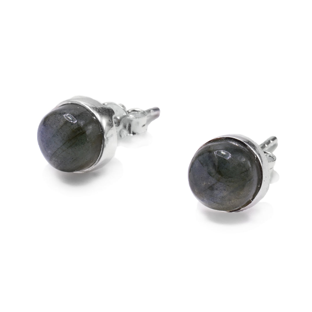 These labradorite earrings studs are made from sterling silver and labradorite gems. The earrings are circle shaped and have round gems held in silver backs. The gems have a rough texture giving the piece a rustic look.