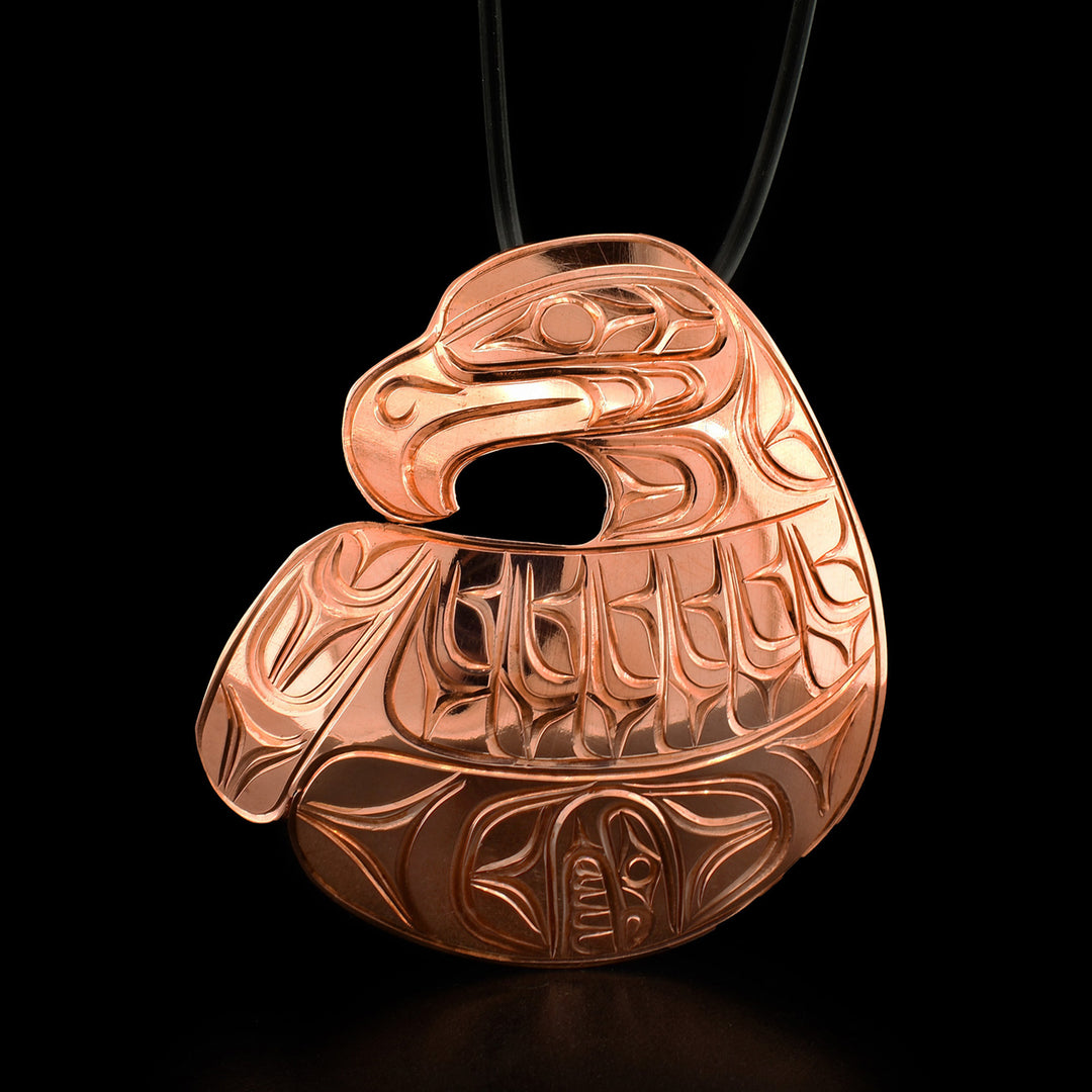 This eagle pendant is in the shape of an eagle with its large wing spread underneath its head. The wing has intricate carvings depicting the bird's feathers.