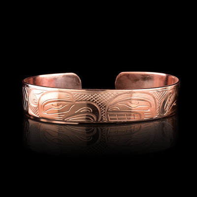 This Eagle and Orca bracelet cuff has a single, thing band with a gap in the back and is made using copper. There are depictions of the Eagle and the Orca that have been beautifully carved into the surface of the band.