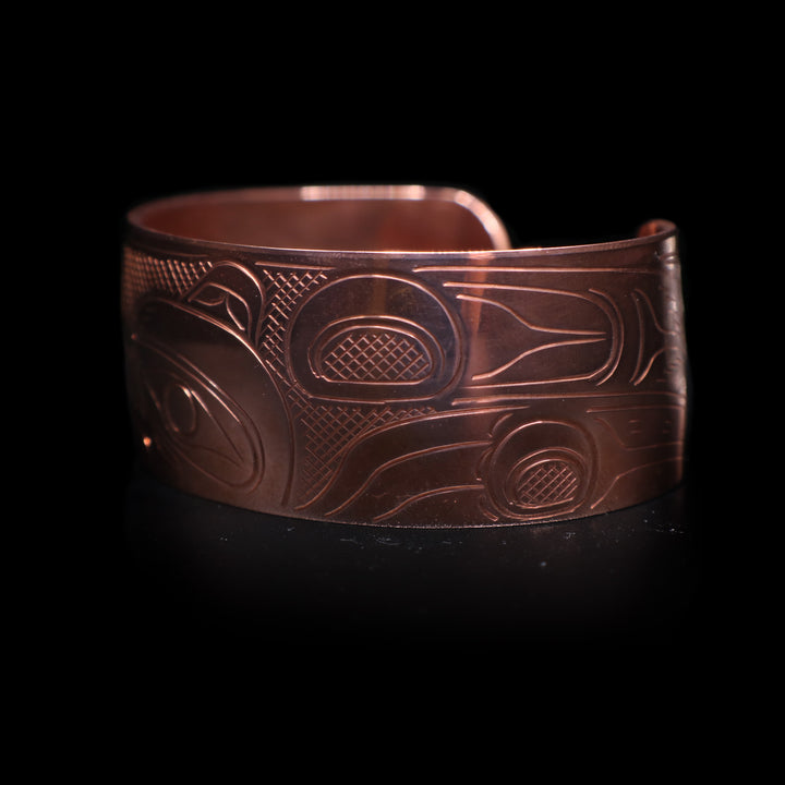 This wide cuff bracelet has a single copper band with a gap in the back. There is a full depiction of the Wolf legend carved across the surface of the band.