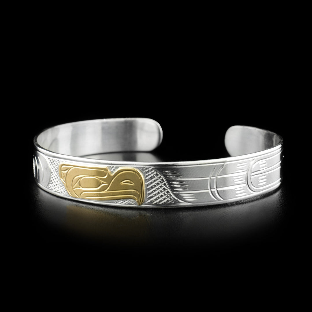 This eagle bracelet depicts the head of an eagle in the center facing the right made fom yellow gold. The background behind has been cross-hatched.