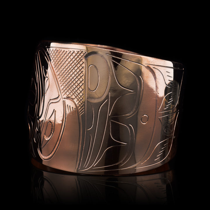 This gorgeous Moon bracelet has been made using copper and has a single, wide bracelet that tapers slightly and has a gap in the back. There is a depiction of the Moon with depictions of the Raven and The Eagle on either side of it that have been beautifully carved into the side of the band. The wings of the legends extend around the surface of the band.