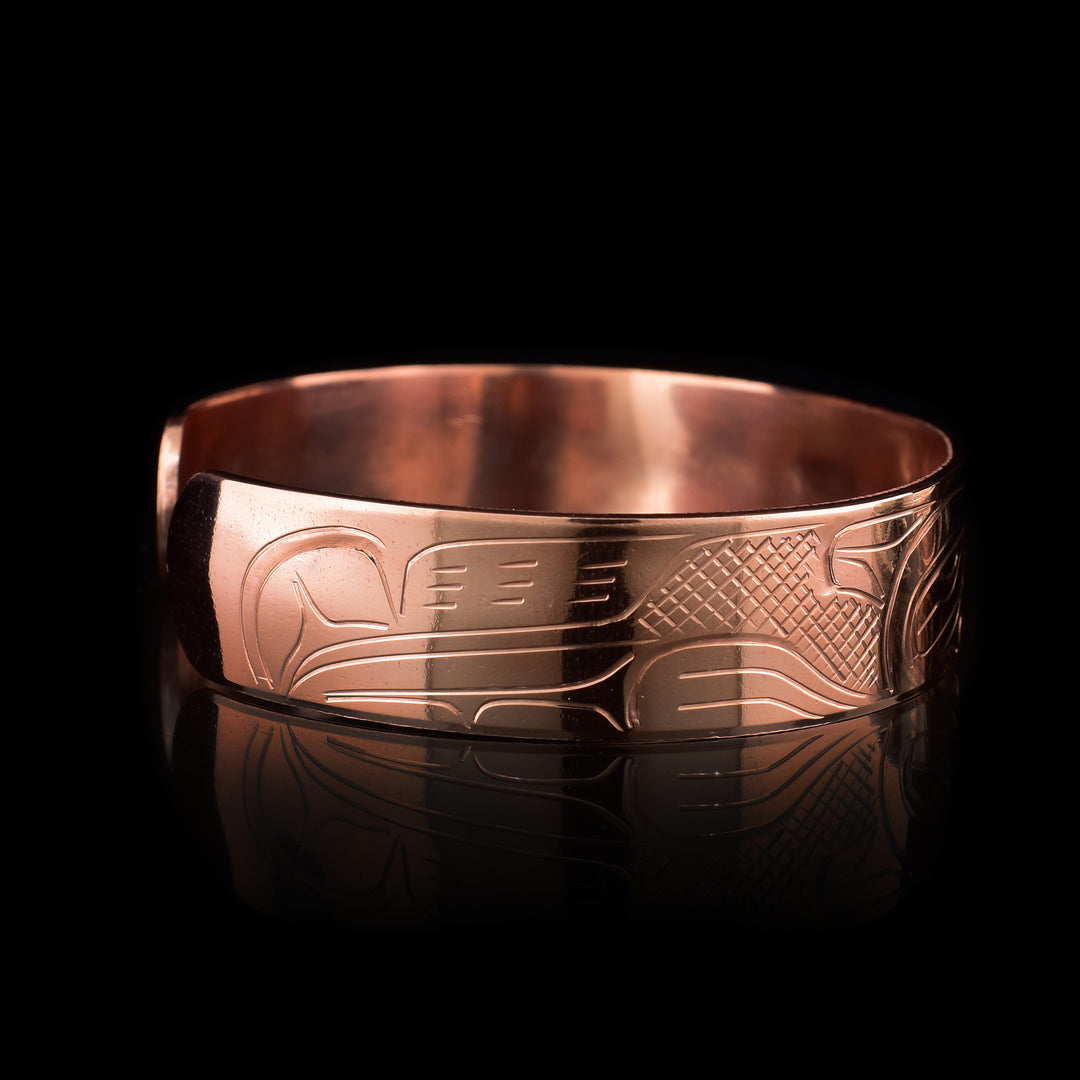 This Wolf bracelet has been made using copper and has a single band with a gap in the back of it. There are two depictions of the Wolf that have been carved into the surface of the band and their heads meet at the top of the band.