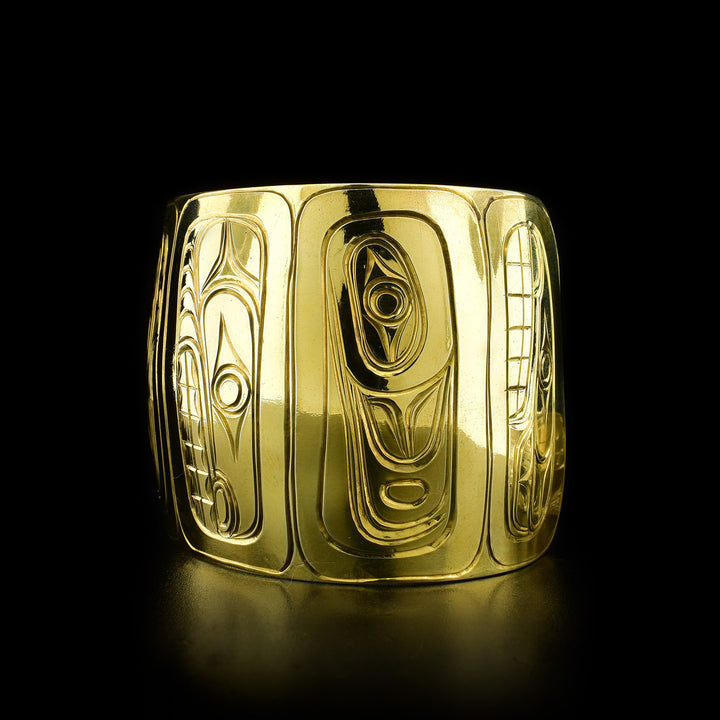 Right angle photo of the brass bracelet shows the legends on the right side of the bracelet including Orca and Raven.