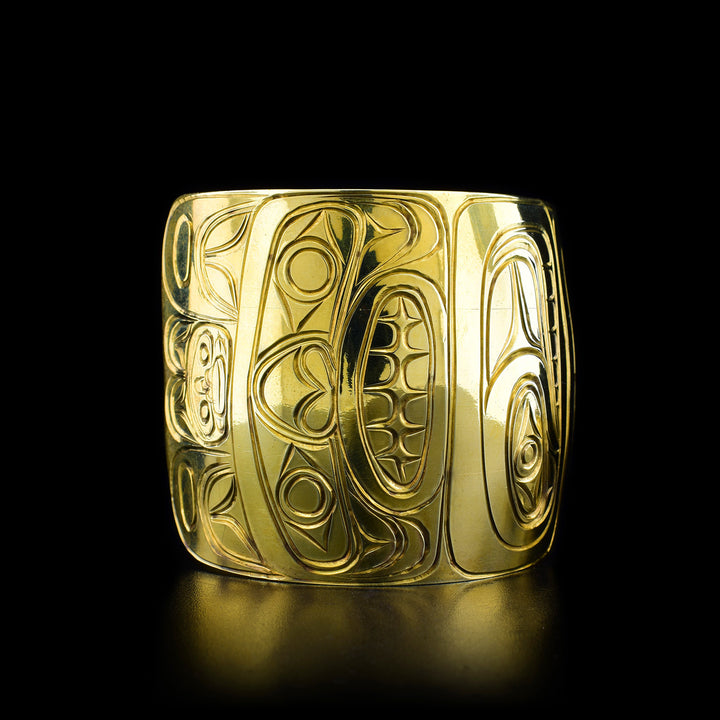 Left angle photo of the brass bracelet shows the Bear legend on the left side of the bracelet. The bear is looking forward with a large snout and teeth visible.