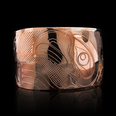 This stunning Eagle bracelet is made using copper and has a single, wide band that tapers slightly and has a gap in the back. There is a large depiction of the Eagle with out-stretched wings beautifully carved into the band. There are cross hatched textures made in the negative space on the piece.