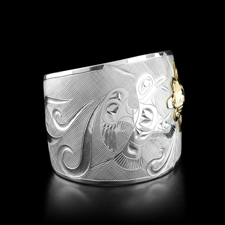 Left angle photo of the bracelet shows the mid-flight raven and carved designs representing the wind.