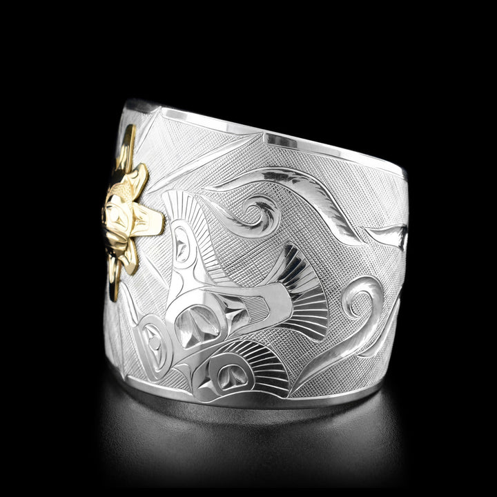 Right angle photo of the bracelet shows the second raven mid-flight followed by carved designs representing the wind.