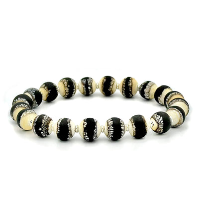 This glass bead bracelet has 20 beads connected on an elastic cord. Each bead is a mixture of black, white, and yellow.