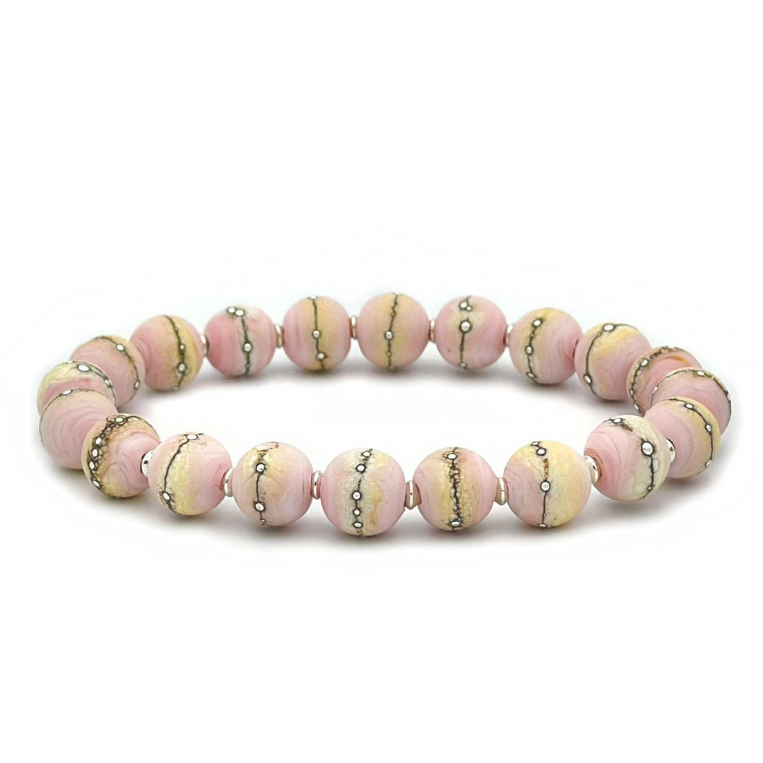 This glass bead bracelet has 20 pink and yellow beads connected on an elastic cord. Each bead has a silver line running through it.