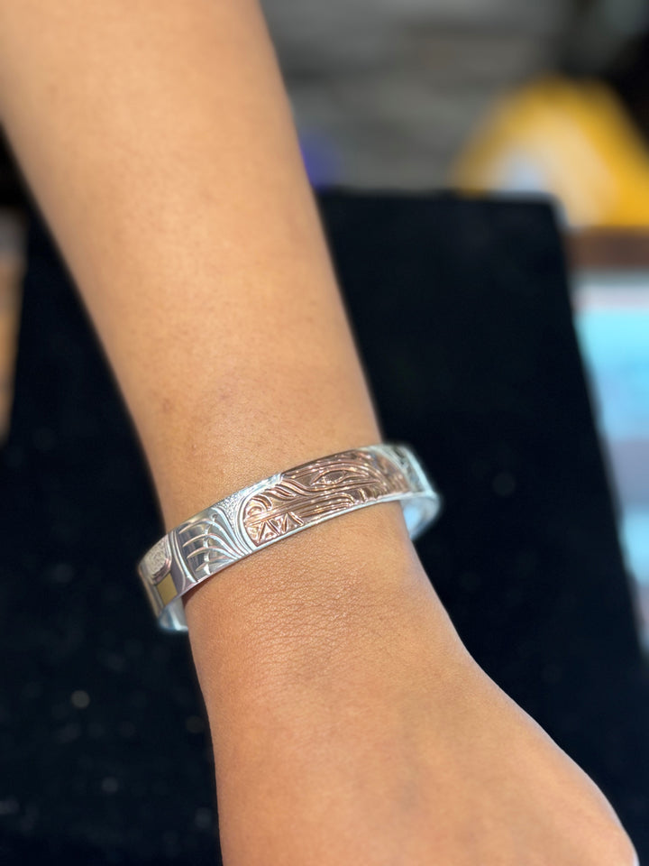 The photo shows a close up of the model's wrist wearing the piece.