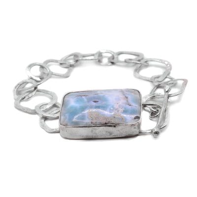 This larimar bracelet depicts a rectangular larimar gemstone as the centerpiece with round, silver links making up the rest of the bracelet.