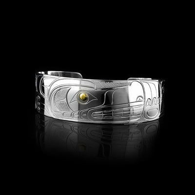 This Wolf bracelet cuff has a single, wide band made from sterling silver. The head of the Wolf is done at a side profile with its ears, snout, eye and teeth detailed. The eye is made using a 14K gold stud and there are paw designs on either side of the head.