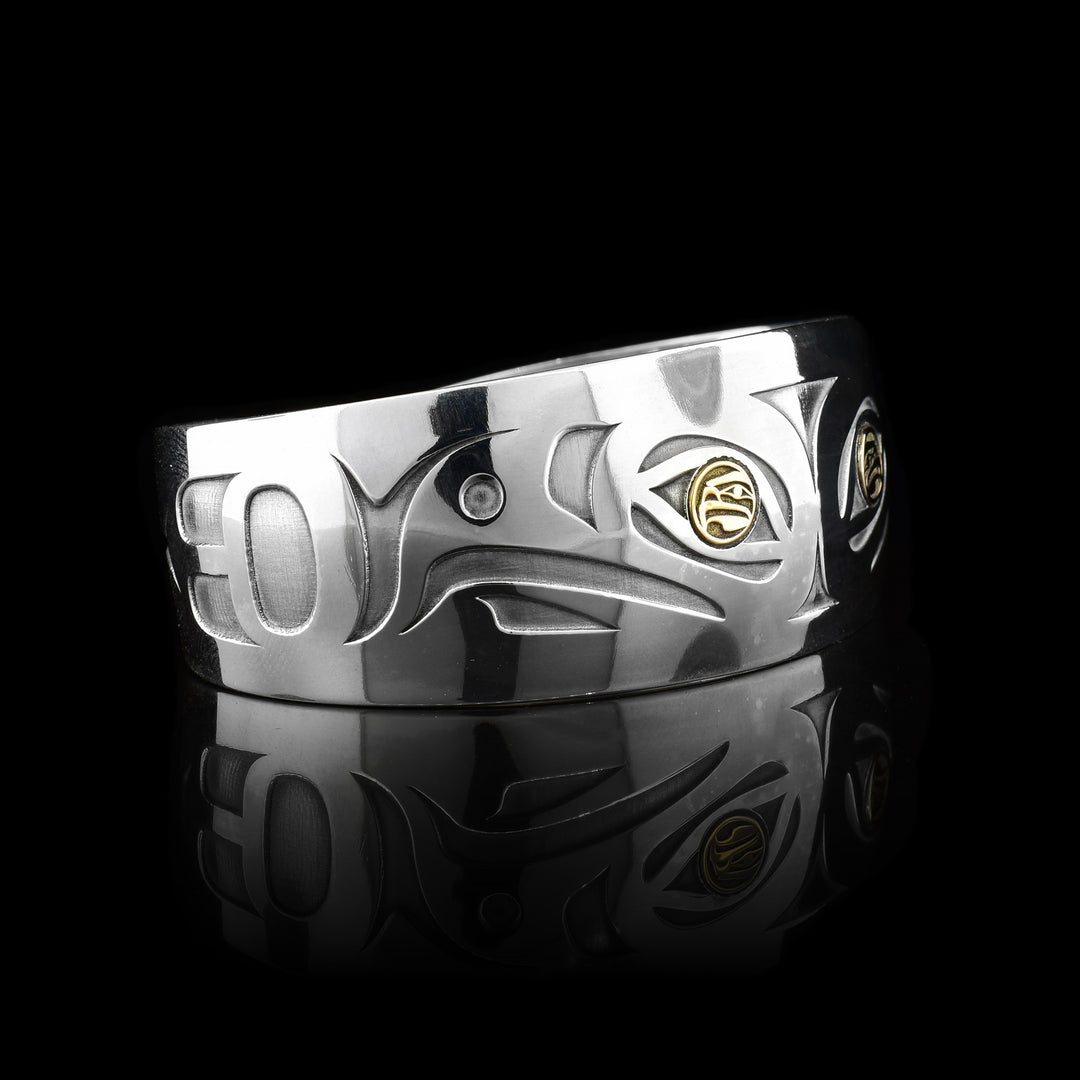 This gorgeous Eagle bracelet is made from sterling silver, 14K gold and has a slightly tapered, wide band with a gap in the back. There are cutout designs depicting two Eagles and there eyes are made from gold and also depict Eagles.