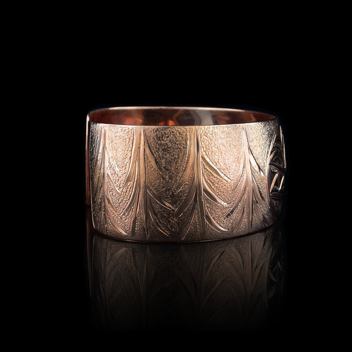 This stunning Wolf bracelet is made using copper and has a single, wide band with a gap in the back. I the center of the band, there is the head of the Baby Wolf placed in the middle of an oval design which represents the womb. On the right end of the band, the mother wolf is depicted with the side profile of her head which is tilted upwards. On the other end of the band there are simple pine trees carved into the band