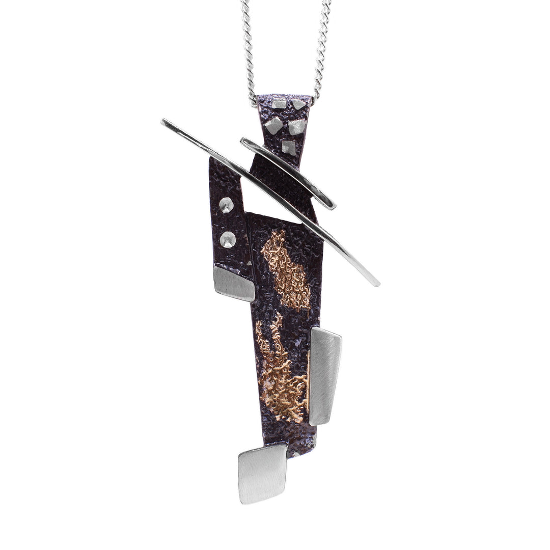 This oxidized silver necklace is an abstract shape with a roof-like slanted top attached to a large, oxidized bail. The bottom of the pendant is made up of dark grey rectangles and sterling silver accents stacked on top of one another.