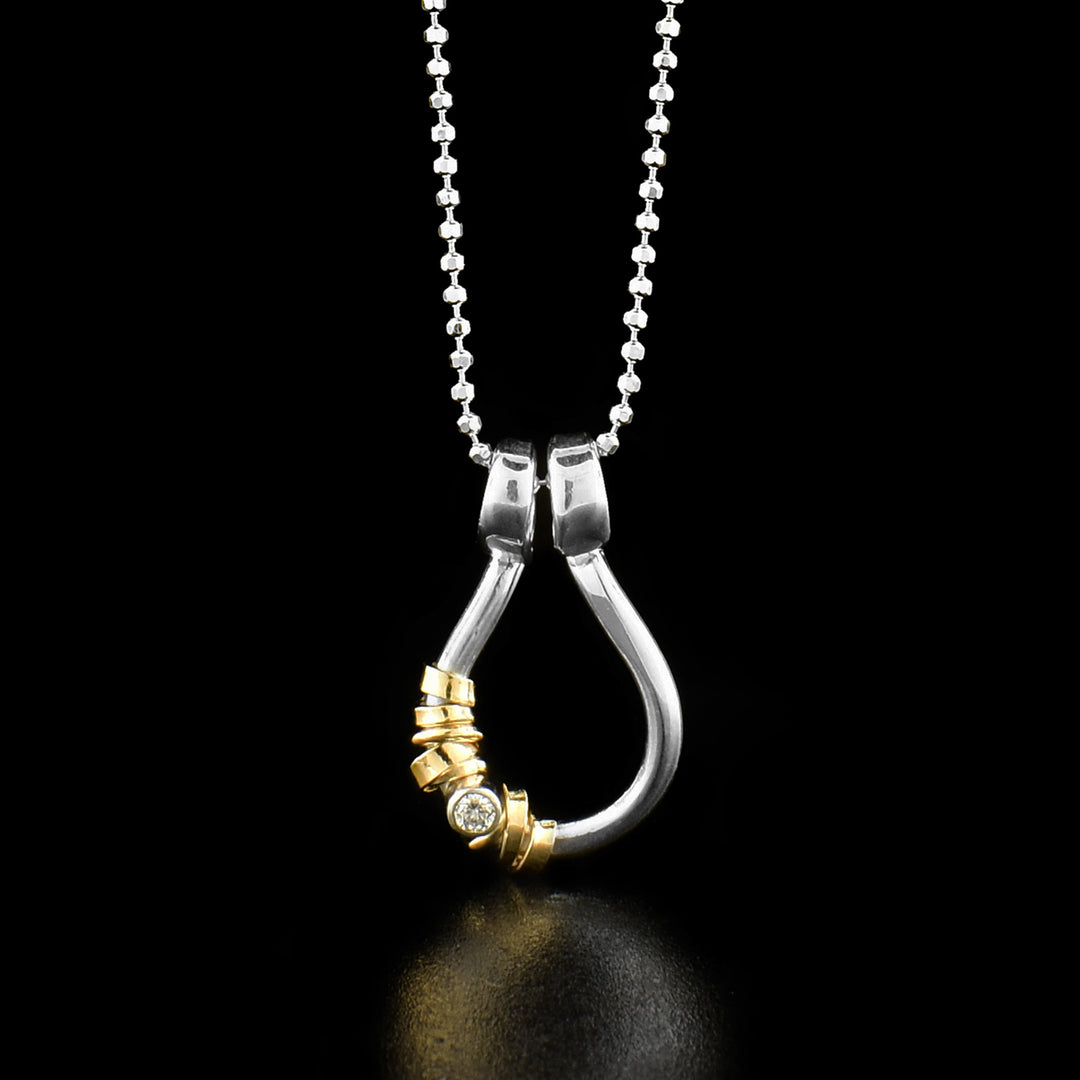 This cubic zirconia pendant necklace has a small teardrop shaped hoop pendant made from sterling silver. There is a cubic zirconia gem held in the pendant with 14K gold filled wraps around the gem