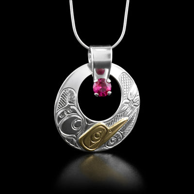 This hummingbird necklace has the profile of a hummingbird in the bottom of the pendant and a large hole cut out in the center. There are carved designs all around the perimeter.