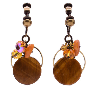 Dangle earrings made of Austrian crystal, handworked brass, Baltic amber, tiger's eye, and glass. Brass clips. By Honica.