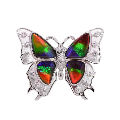 Sterling silver butterfly brooch with ammolite in wings. Adorned with white sapphires. By Enchanted Designs.