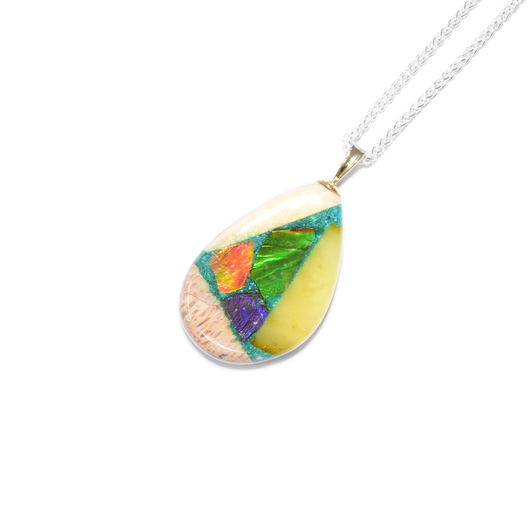 Uneven teardrop shape. Pendant is a mosaic of ammolite, lapis, malachite, turquoise, sugilite, rhodochrosite, red coral, amber, mammoth ivory and gold nuggets. 14K gold bail.