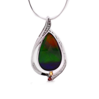 A pear shaped pendant with a teardrop ammolite center piece surrounded by a sterling silver border with sapphires, citrine, and garned stone embedded in it.