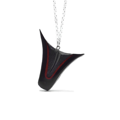 Downwards-pointing black argillite dorsal fin pendant with strip of red argillite. Hand-carved by Haida artist Amy Edgars.