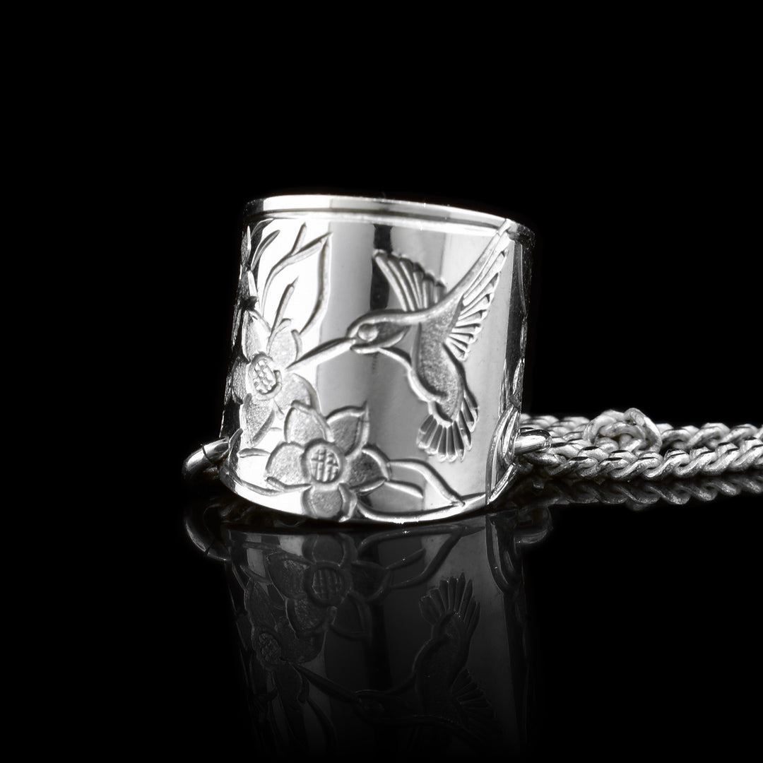 This ear hoop band is made from sterling silver and has a wide band with a gap in the back. There are depictions of hummingbirds and rose flowers that have been crafted into the band. The piece can fit around your ear without any piercings.