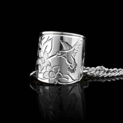 This ear hoop band is made from sterling silver and has a wide band with a gap in the back. There are depictions of hummingbirds and rose flowers that have been crafted into the band. The piece can fit around your ear without any piercings.