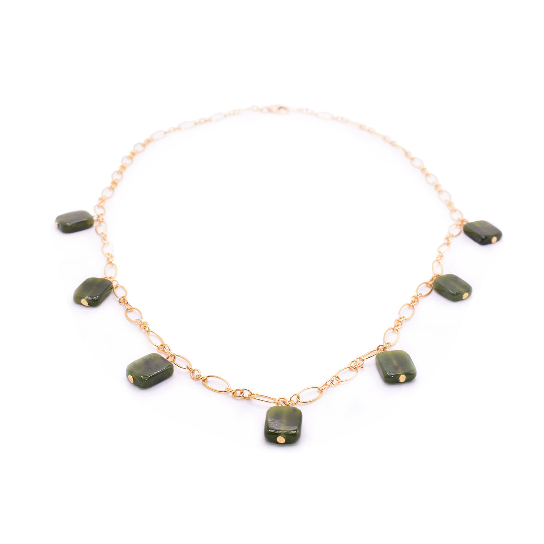 This gold jade necklace has a dainty 14K gold filled chain and there are several BC jade charms around it. The jade is shaped like small rectangles and are attached with gold filled facets. There is not jade where the necklace rests on the neck.