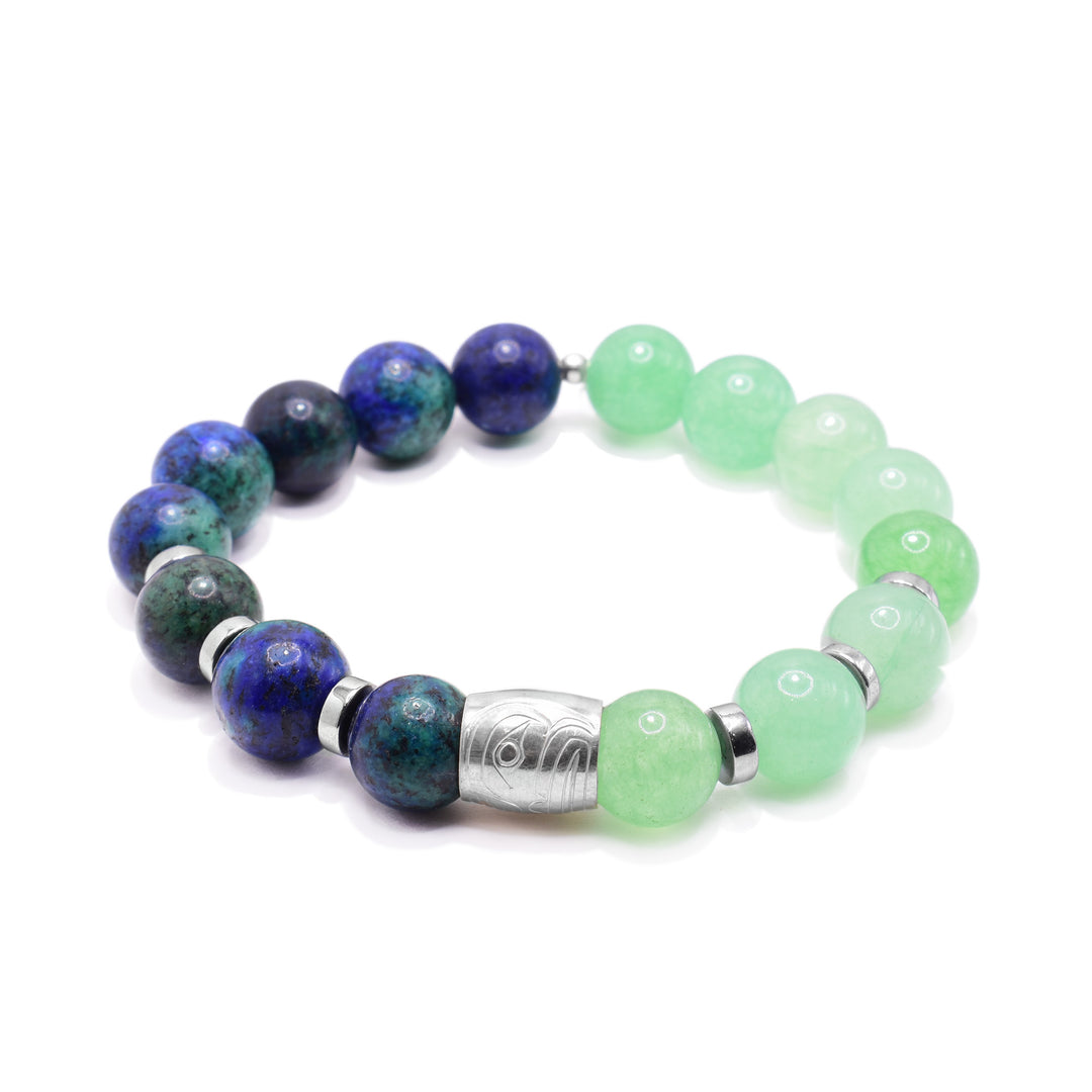 This green aventurine bracelet has blue chrysocolla and green aventurine sphere shaped beads. Half is the blue stones and the other is the green stones and there are round, flat sterling silver spacers in between them. In the center of the piece there is a small spirit bead made from sterling silver. There is a depiction of the face of the Frog carved into it.