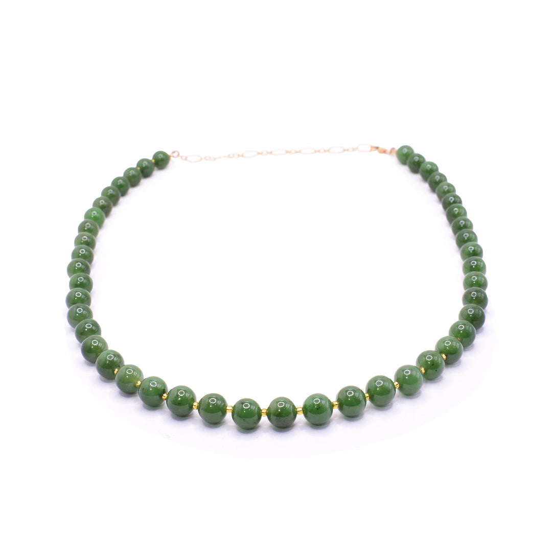 This dainty jade and gold necklace has small, sphere shaped jade beads that run around the entire length of the piece. There are much smaller 14K gold filled bead spacers between all the jade beads. There is a gold filled extender in the back.