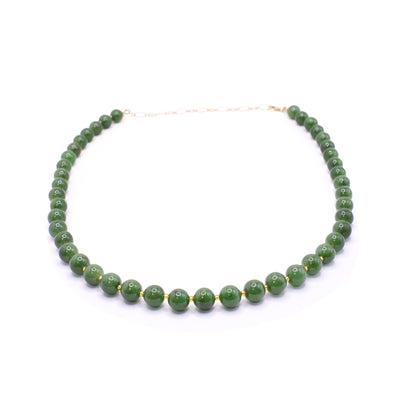 This dainty jade and gold necklace has small, sphere shaped jade beads that run around the entire length of the piece. There are much smaller 14K gold filled bead spacers between all the jade beads. There is a gold filled extender in the back.