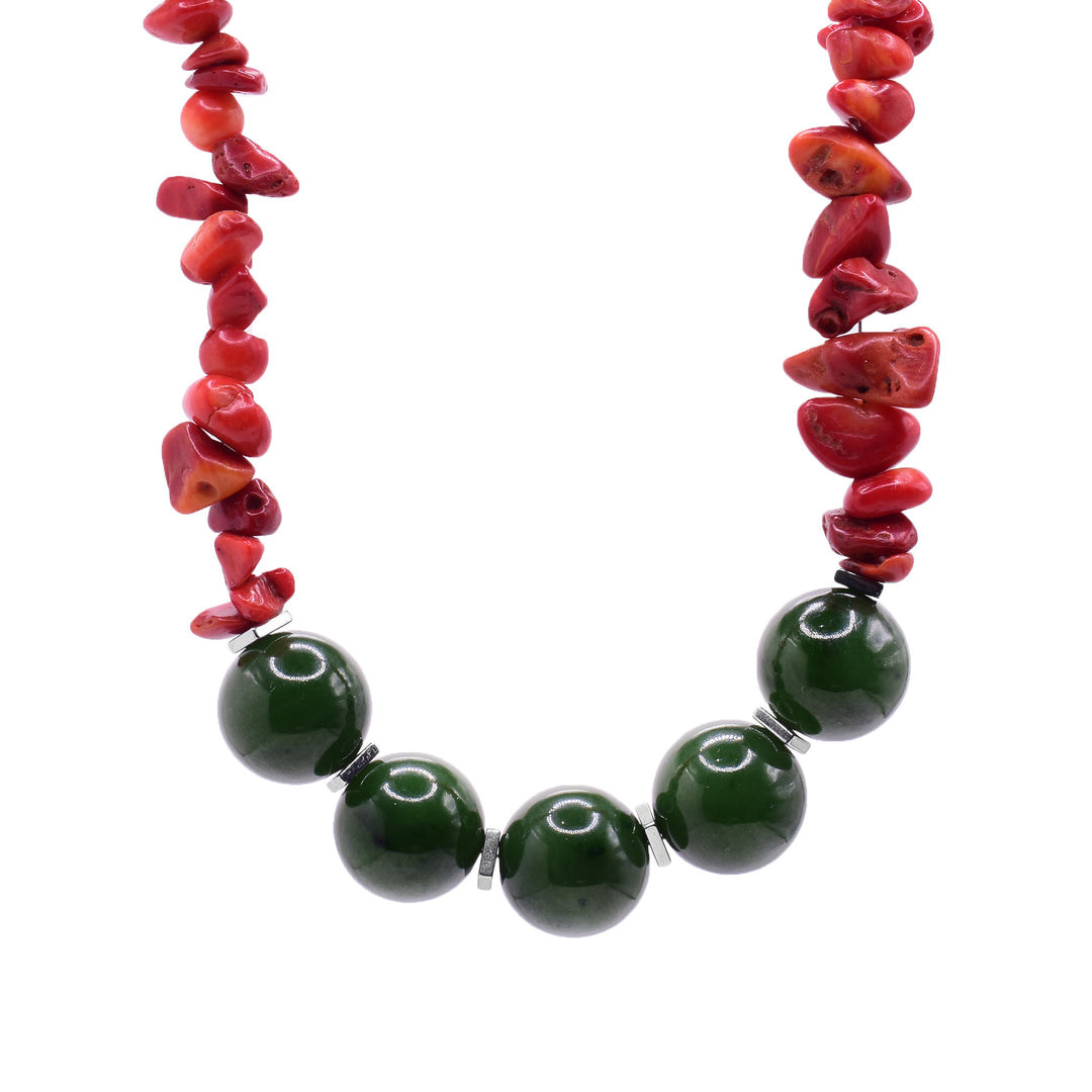 This colorful beaded necklace has small, chunky beads made from red bamboo coral. At the bottom of the necklace are five large, sphere jade beads with tiny, hematite beads in between them.