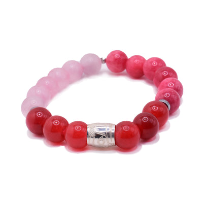 This multi color quartz bracelet has pink and red quartz beads, that are spheres, and one sterling silver spirit bead. There are carvings made across the surface of the bead that depict the Raven.