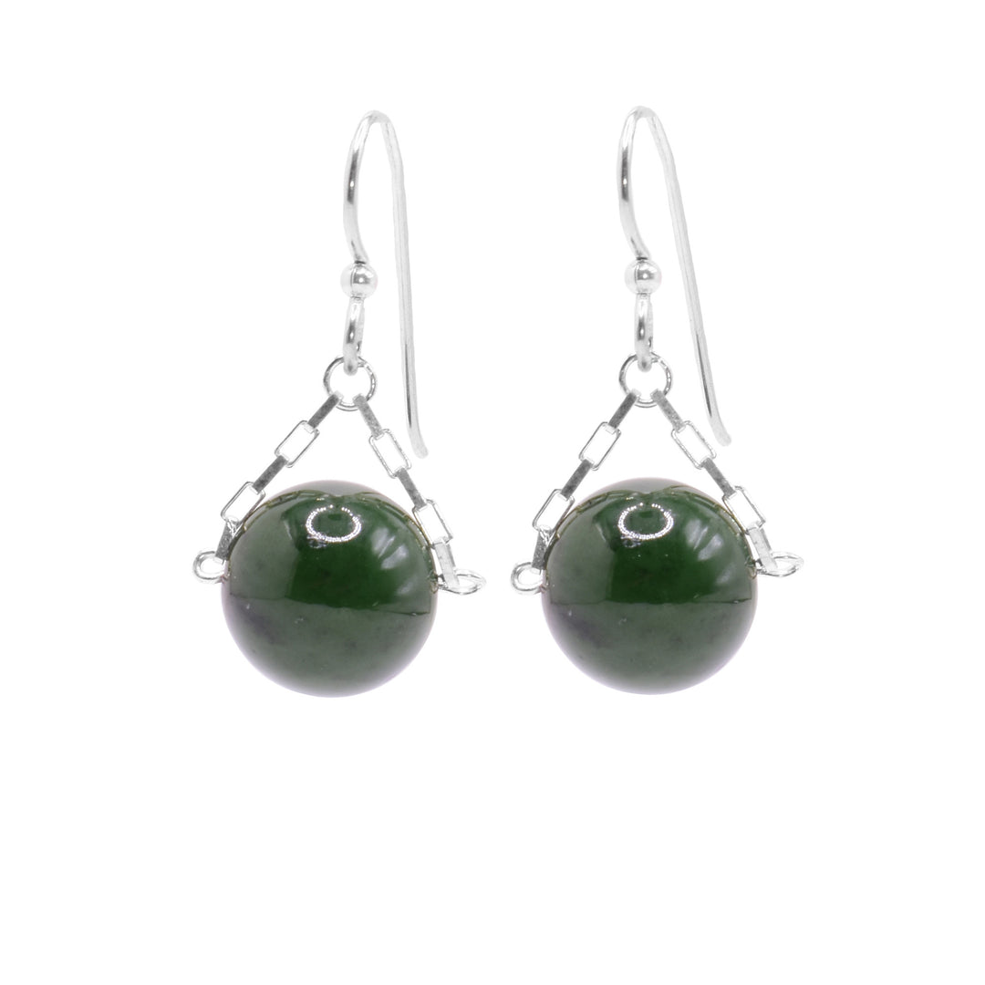 These jade drop earrings have small, sterling silver chains attached to the hooks and to either side of the jade hangs. The jade are large spheres and dangle from the small chains.
