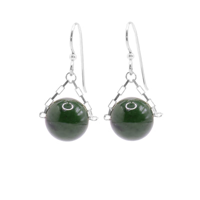 These jade drop earrings have small, sterling silver chains attached to the hooks and to either side of the jade hangs. The jade are large spheres and dangle from the small chains.
