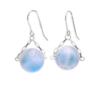 These larimar drop earrings have small, sterling silver chains attached to the hooks and to either side of the larimar hangs. The larimar are large spheres and dangle from the small chains.