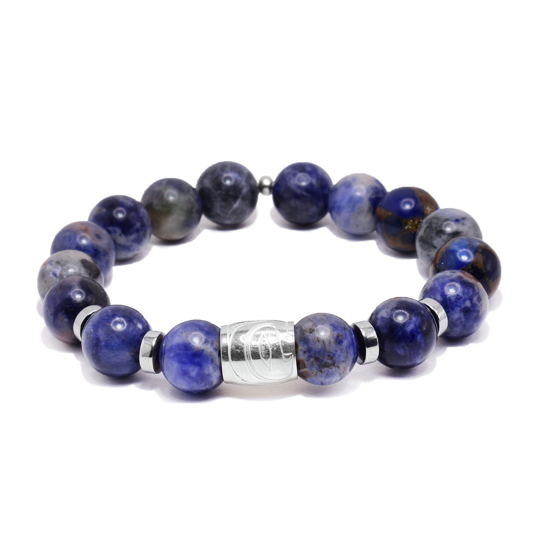 This sterling silver and jasper bracelet has sphere beads made from jasper and flat circle hematite spacers. There is a spirit bead featured on the piece with a depiction of the Hummingbird carved into it.