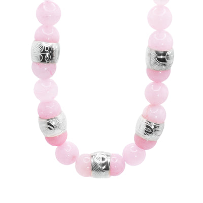 This chunky rose quartz necklace has sphere shaped gemstone beads that are larger at the bottom portion of the piece and smaller at the tops of it. There are five sterling silver spirit beads that are ditributef through the large beads. The spirit beads have depictions of the Hummingbird, the Sun, the Swan, a dragonfly and a feather carved into the surface of them.
