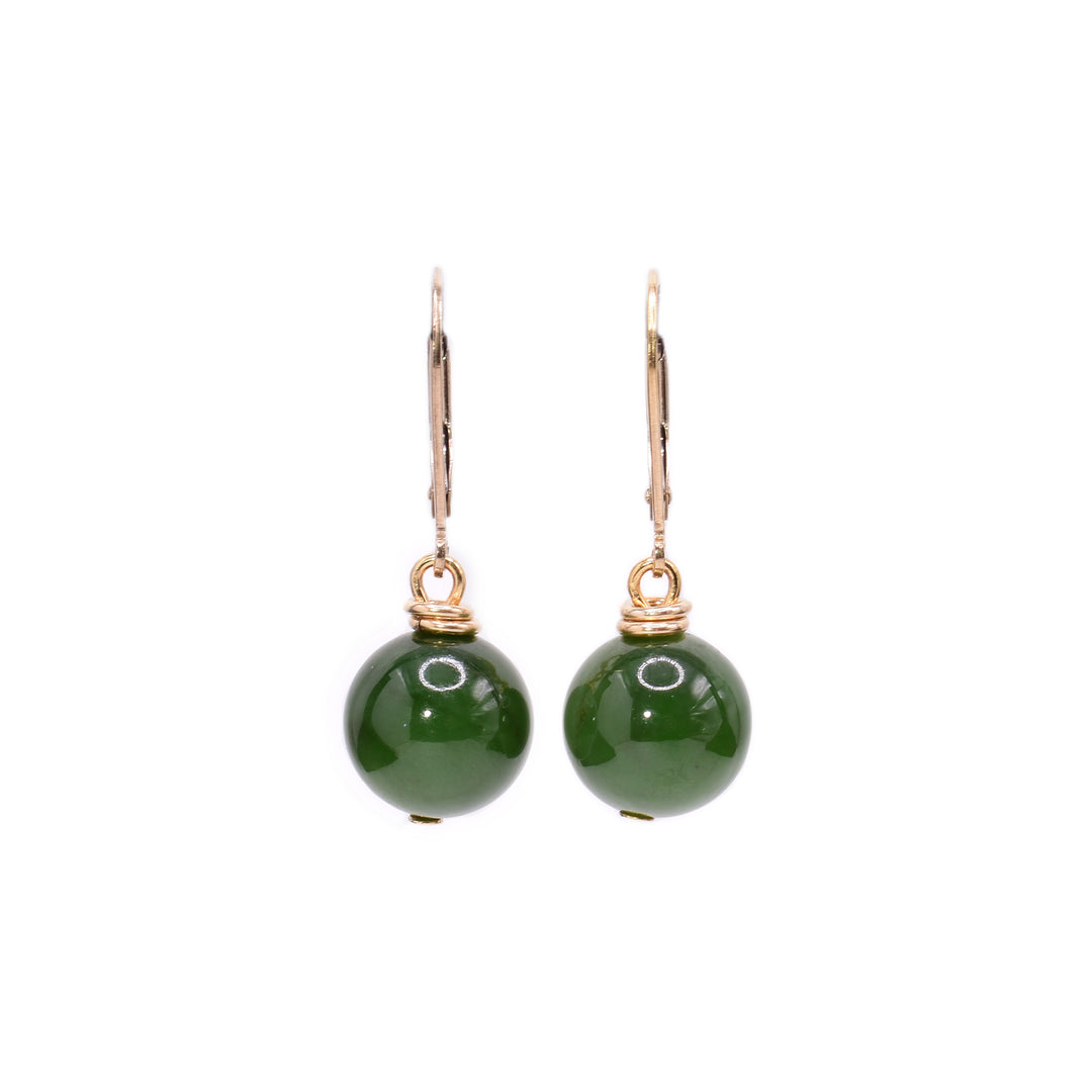 These BC jade earrings have jade spheres dangling from lever back hooks. There are 14K gold filled wires that attach to the hooks and coil twice around the top of the jade balls.