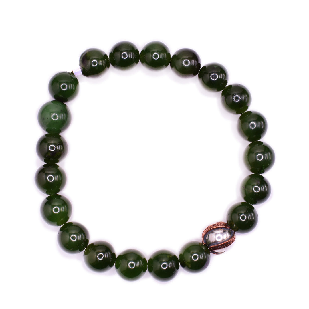 This beaded jade bracelet is made from BC jade, sterling silver and copper. The beads are made from jade and are small and spherical. There is one accent bead that is made from silver and has copper patterns on it.